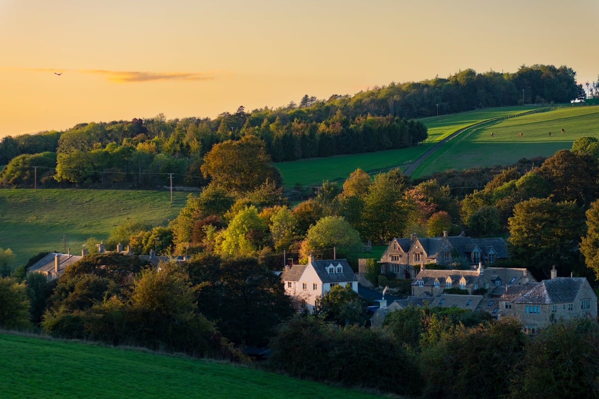 Traditional English village rooftops and stone houses at sunset in the countryside